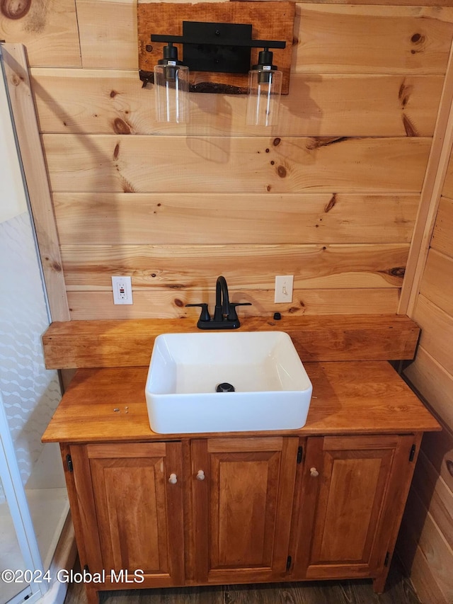 bathroom with vanity and wooden walls