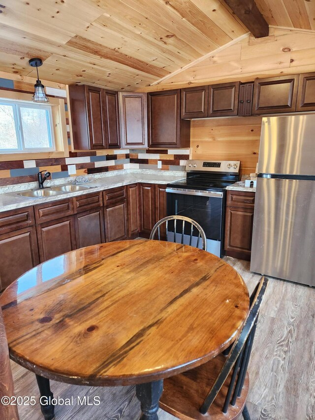 kitchen featuring wooden ceiling, sink, light hardwood / wood-style flooring, appliances with stainless steel finishes, and decorative light fixtures