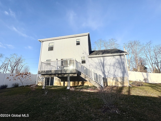 back of property with a wooden deck and a yard