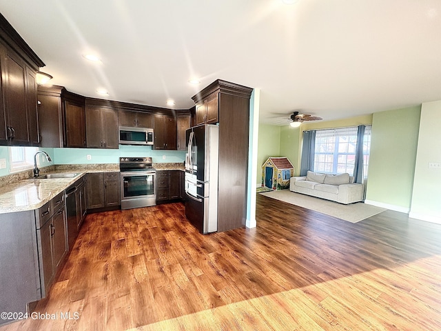 kitchen featuring dark brown cabinets, dark hardwood / wood-style flooring, stainless steel appliances, and sink