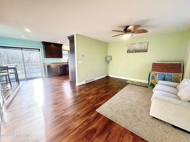 living room featuring ceiling fan and dark hardwood / wood-style floors