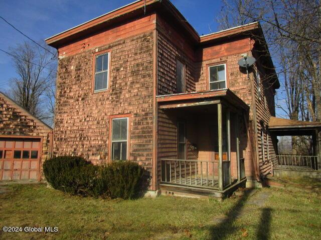 exterior space with covered porch and a lawn