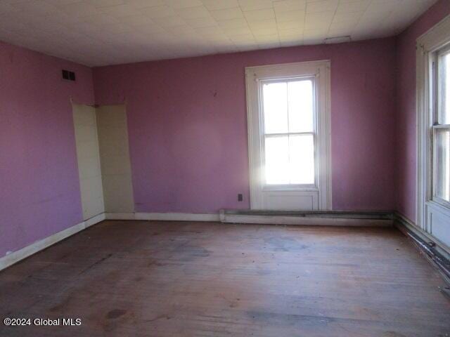 unfurnished room featuring hardwood / wood-style floors and plenty of natural light