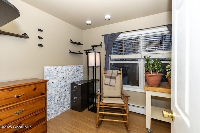 living area with a baseboard radiator and hardwood / wood-style flooring