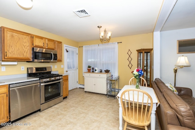 kitchen featuring appliances with stainless steel finishes, a baseboard radiator, and an inviting chandelier