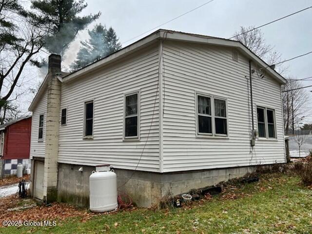 view of side of home with a lawn