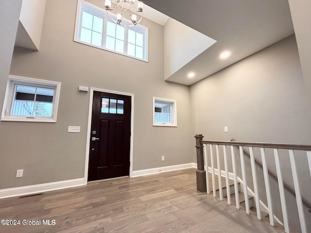 entrance foyer featuring a chandelier, a high ceiling, and wood-type flooring