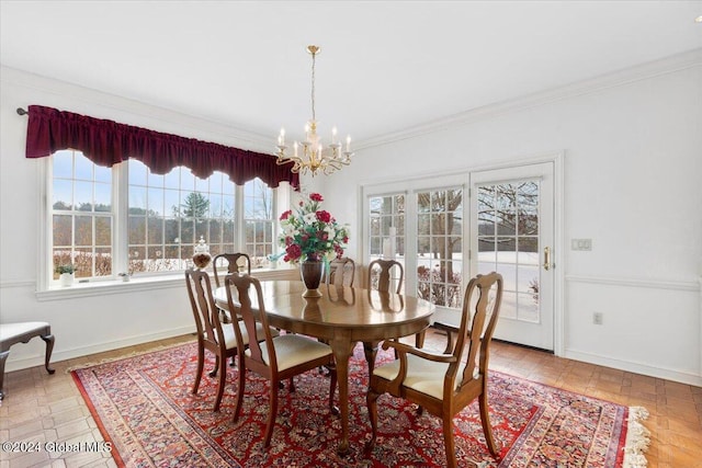 dining space featuring crown molding and a chandelier