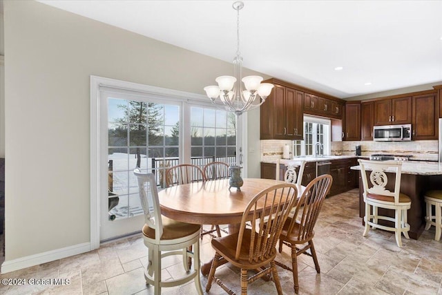 dining space featuring an inviting chandelier and sink