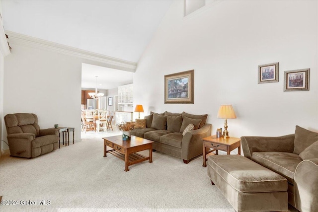 carpeted living room with high vaulted ceiling and a notable chandelier