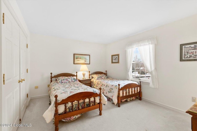 bedroom with light carpet and a closet