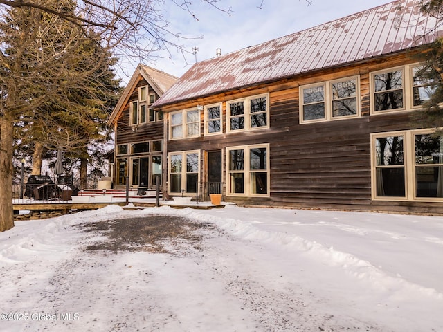 view of snow covered rear of property