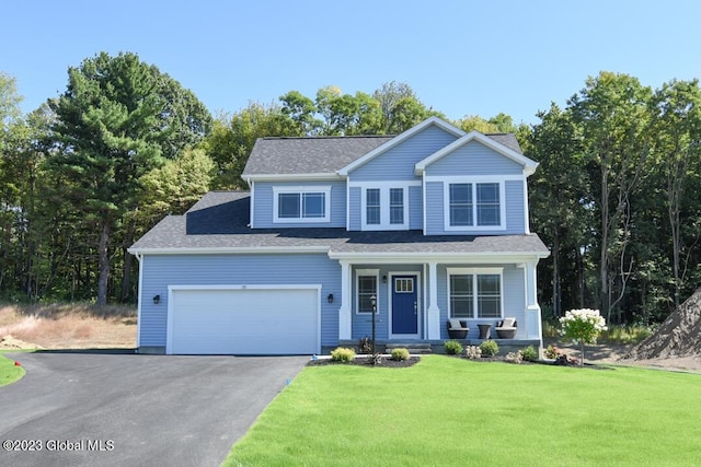 view of front of property with a front lawn, covered porch, and a garage