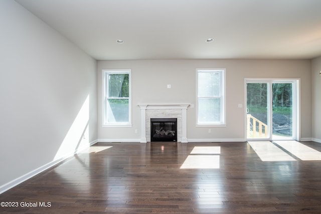 unfurnished living room featuring dark hardwood / wood-style flooring and a wealth of natural light