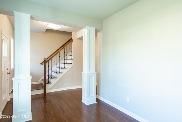 interior space featuring dark wood-type flooring and decorative columns