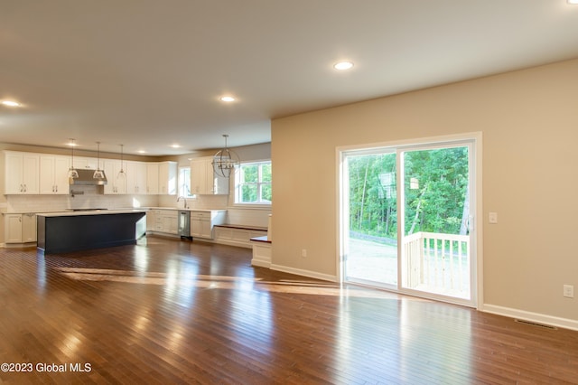 unfurnished living room with dark hardwood / wood-style flooring and a notable chandelier