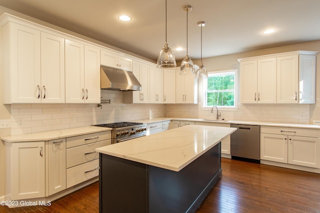 kitchen featuring appliances with stainless steel finishes, sink, white cabinets, hanging light fixtures, and a center island