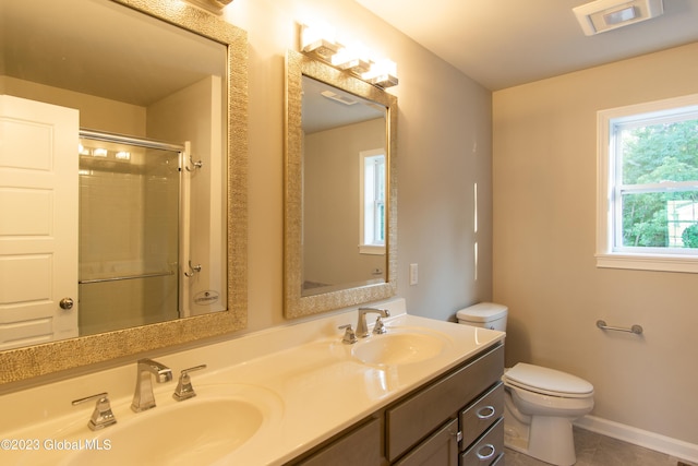 bathroom with tile patterned flooring, vanity, a shower with shower door, and toilet