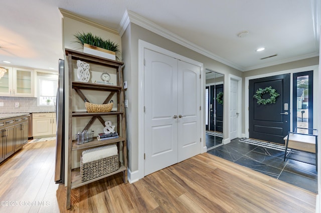 entrance foyer with crown molding and dark wood-type flooring