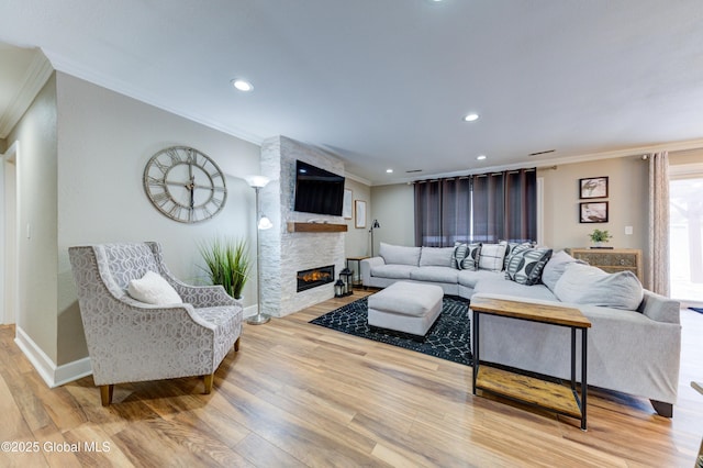 living room featuring ornamental molding, a stone fireplace, and hardwood / wood-style floors