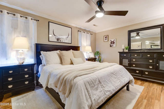 bedroom with ceiling fan, crown molding, and light hardwood / wood-style flooring