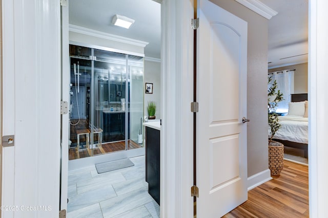 hall with light hardwood / wood-style flooring and crown molding