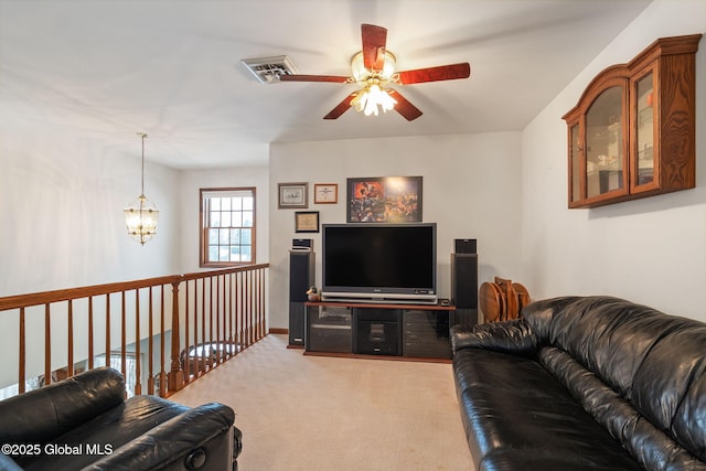 carpeted living room featuring ceiling fan with notable chandelier