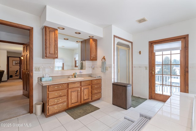 bathroom with tile patterned flooring, vanity, and tile walls