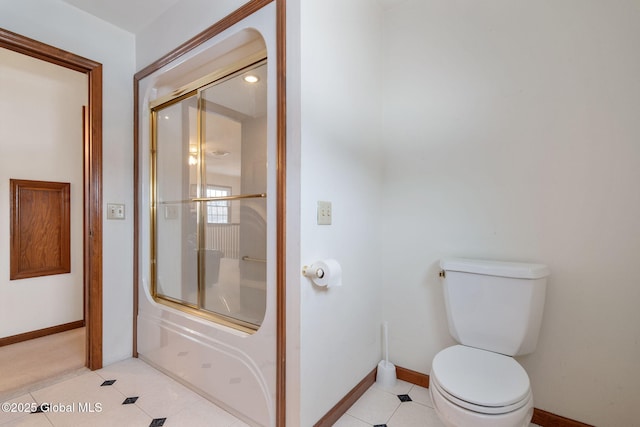 bathroom with tile patterned floors, toilet, and shower / bath combination with glass door