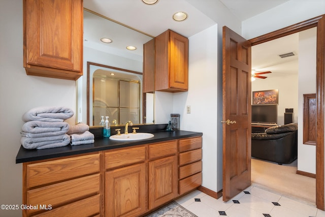 bathroom with tile patterned floors, ceiling fan, vanity, and a shower with shower door