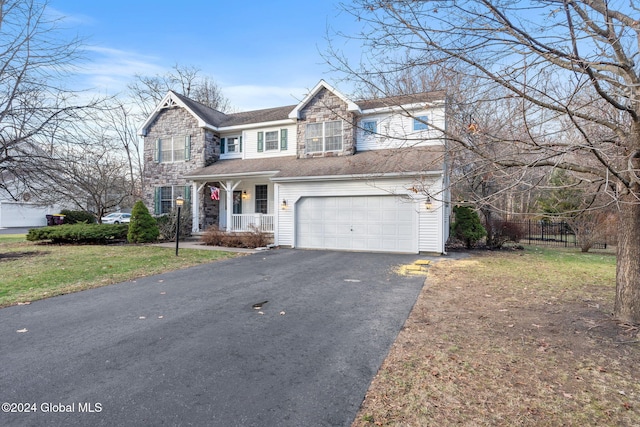 view of front facade featuring a garage, covered porch, and a front lawn