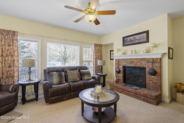 living room featuring a brick fireplace, light carpet, ceiling fan, and plenty of natural light