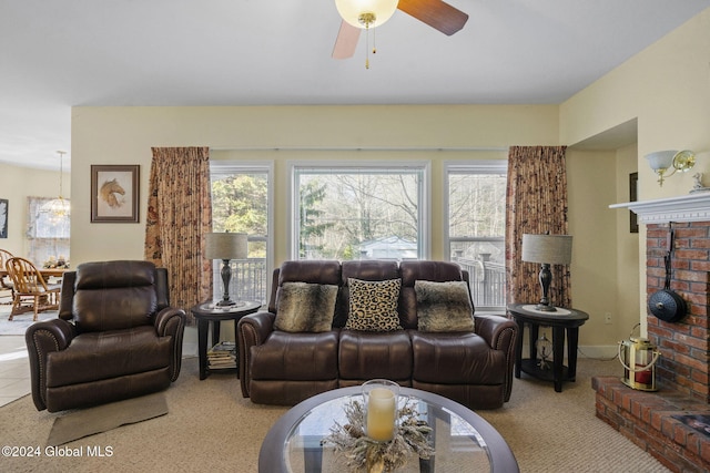 carpeted living room with a brick fireplace and ceiling fan