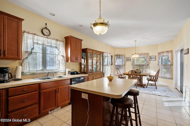 kitchen with sink, a center island, a kitchen bar, light tile patterned floors, and pendant lighting