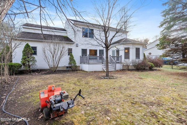 rear view of house with a yard and a wooden deck