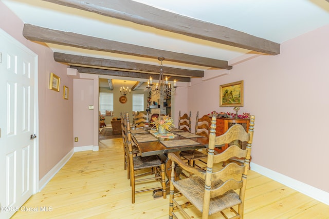 dining area featuring beam ceiling, hardwood / wood-style floors, and an inviting chandelier