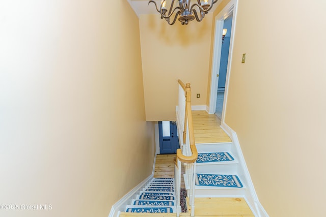 stairs featuring a notable chandelier