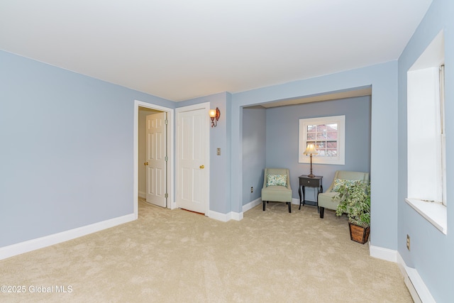 sitting room featuring light carpet