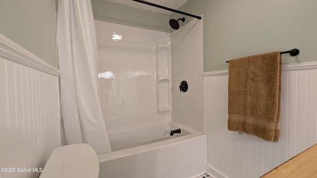 bathroom with shower / tub combo, hardwood / wood-style flooring, and toilet