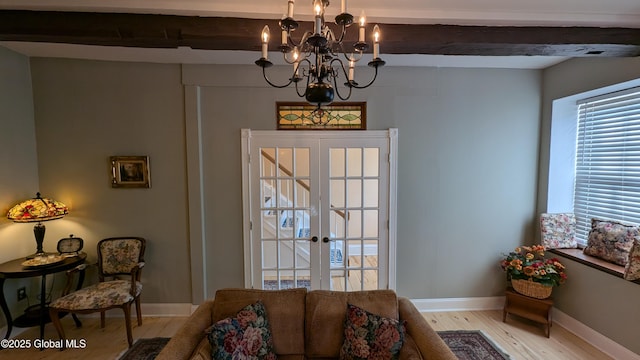 living room with beamed ceiling, french doors, an inviting chandelier, and light hardwood / wood-style flooring