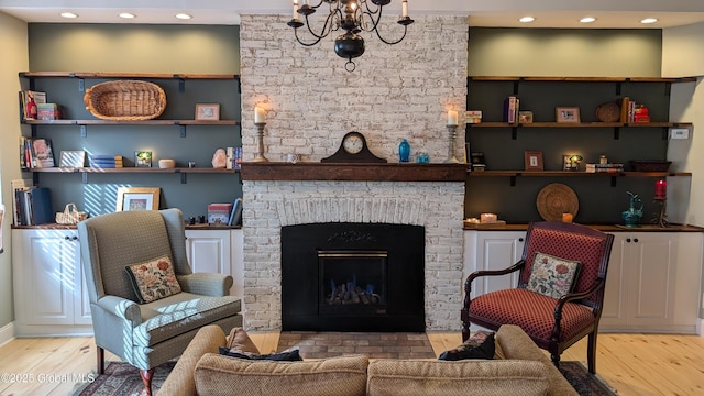 living room featuring a fireplace, hardwood / wood-style flooring, and a chandelier