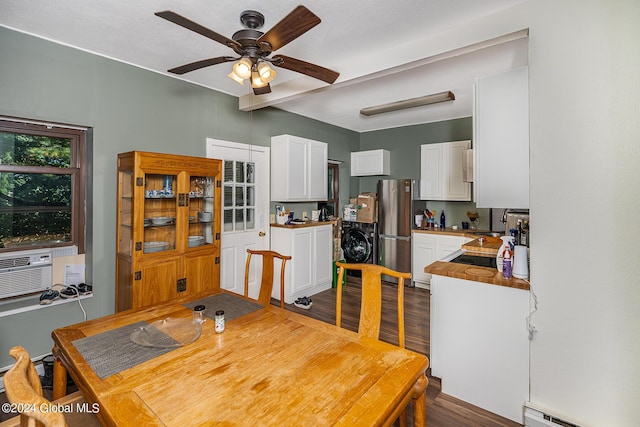 dining space featuring sink, ceiling fan, a baseboard radiator, dark hardwood / wood-style flooring, and washer / dryer