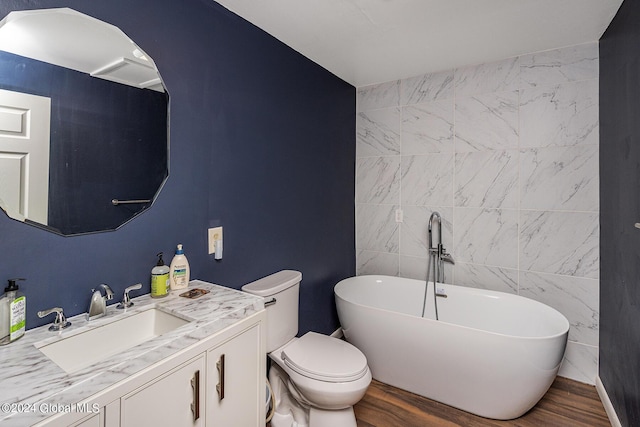 bathroom featuring a bathtub, vanity, toilet, tile walls, and wood-type flooring