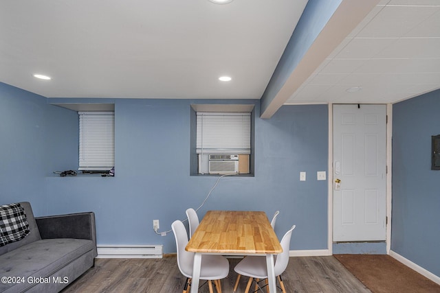 dining area with wood-type flooring, baseboard heating, and cooling unit