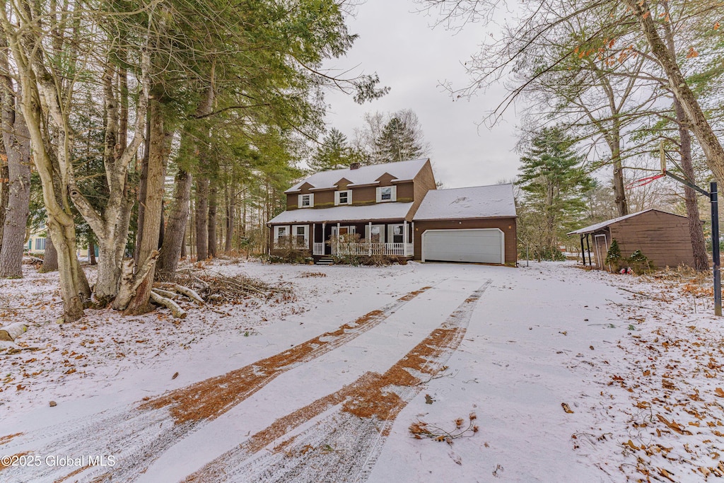 cape cod house featuring a porch and a garage