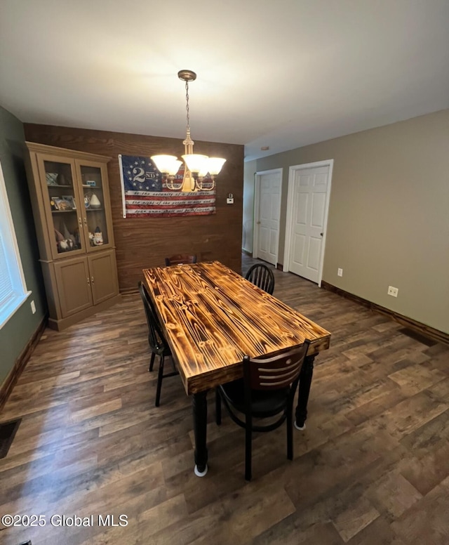 dining area featuring dark wood-type flooring and a chandelier