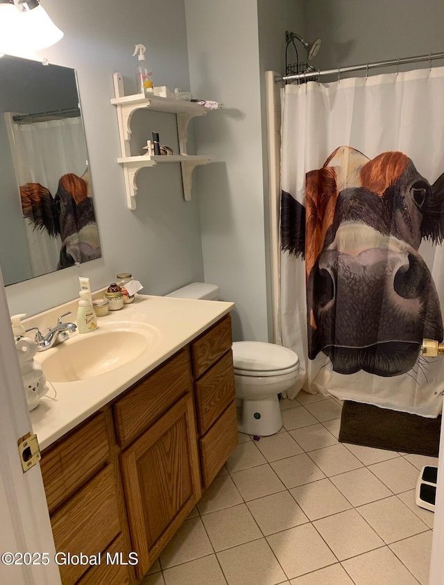 bathroom featuring toilet, vanity, tile patterned floors, and a shower with shower curtain