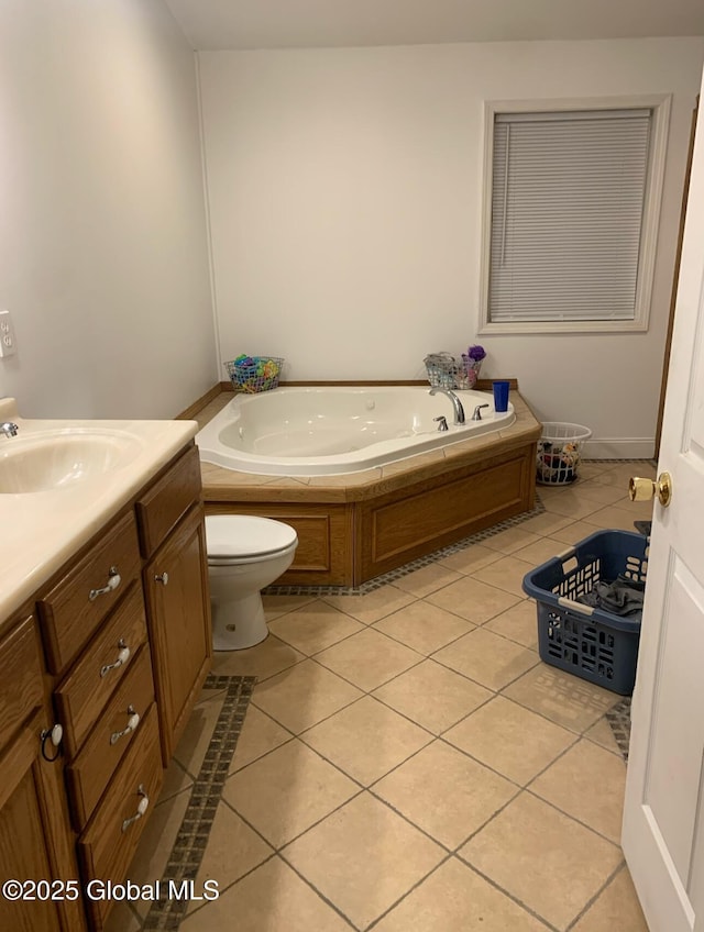 bathroom with tile patterned flooring, vanity, toilet, and a tub