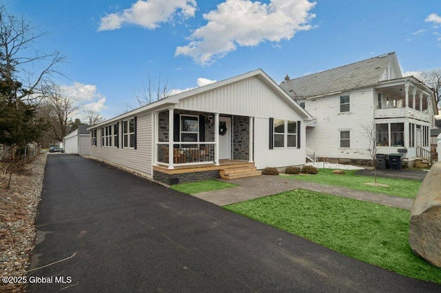 view of front of property featuring an outdoor structure, a front yard, and a garage