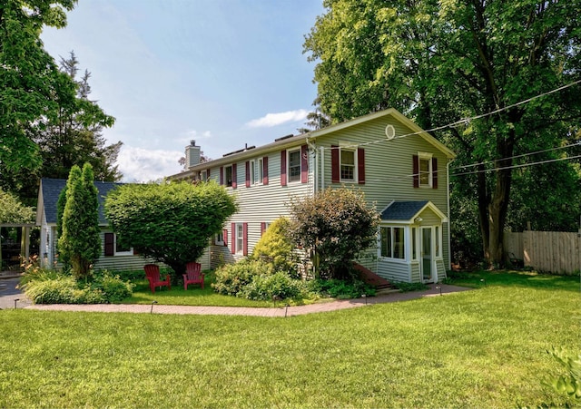 colonial inspired home featuring a front lawn